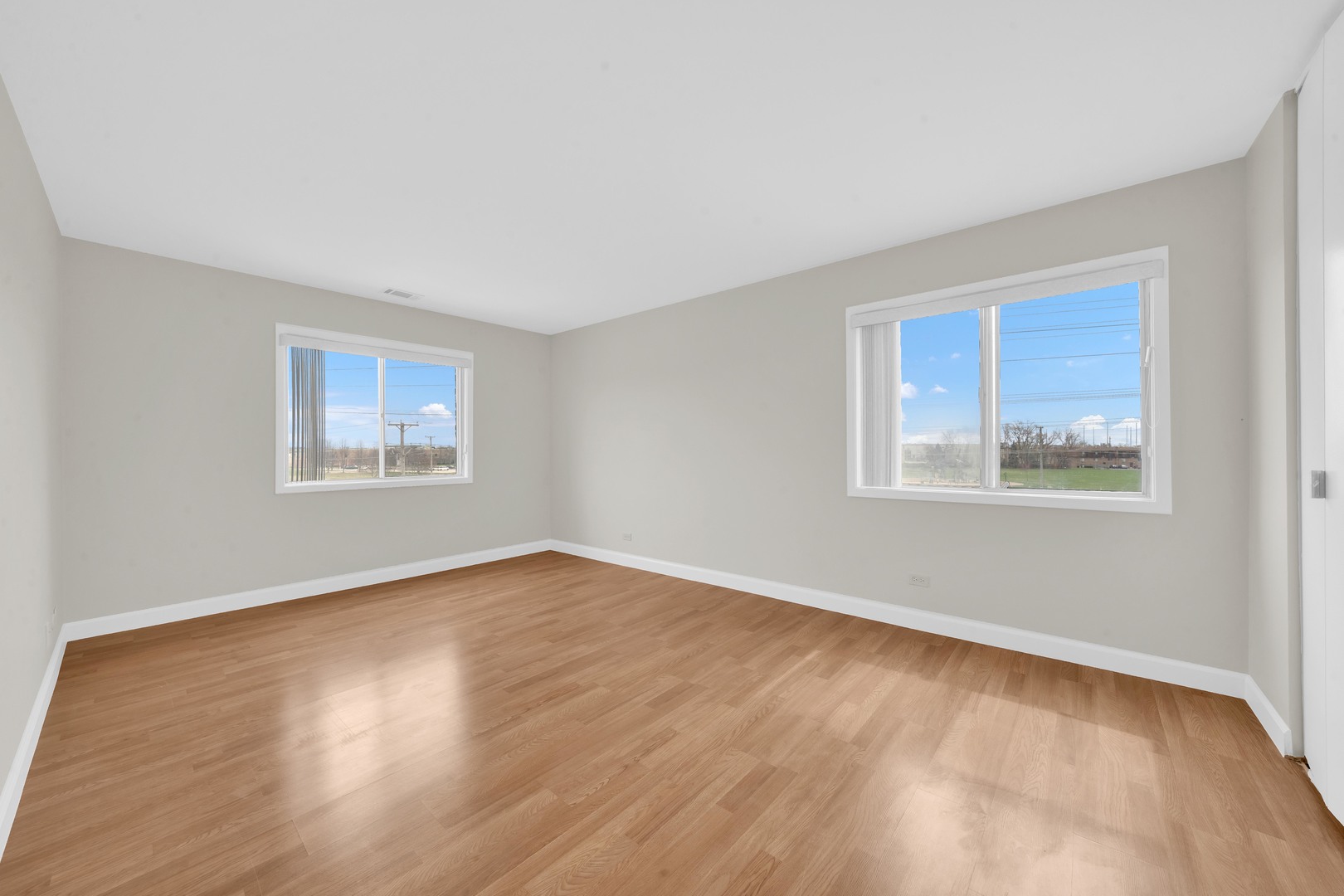 725 West Huntington Commons Road, Unit 314 Mount Prospect, IL 60056 - Photo 17 of 24 a view of an empty room with wooden floor and a window
