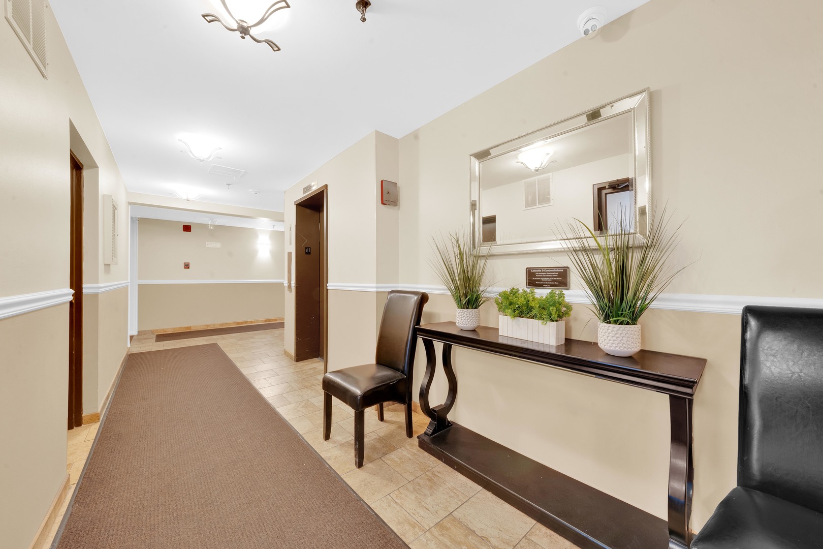 725 West Huntington Commons Road, Unit 314 Mount Prospect, IL 60056 - Photo 23 of 24 a view of a hallway with wooden floor and a potted plant