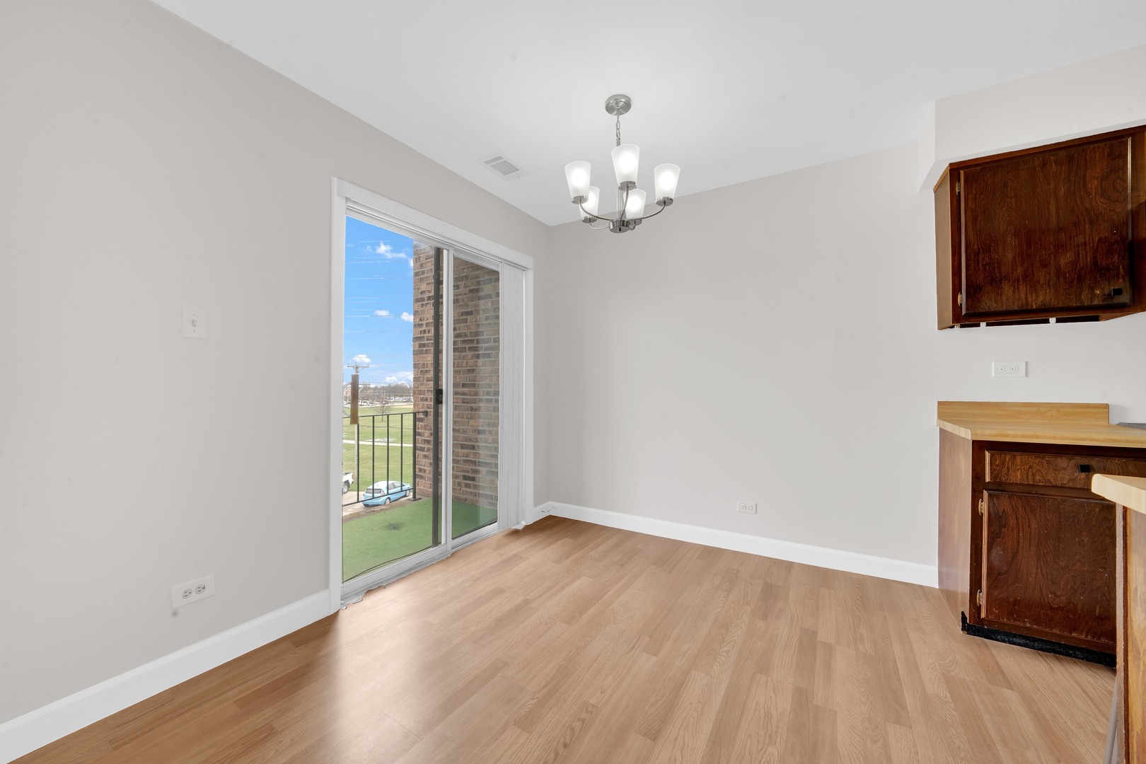 725 West Huntington Commons Road, Unit 314 Mount Prospect, IL 60056 - Photo 8 of 24 wooden floor in an empty room with a window