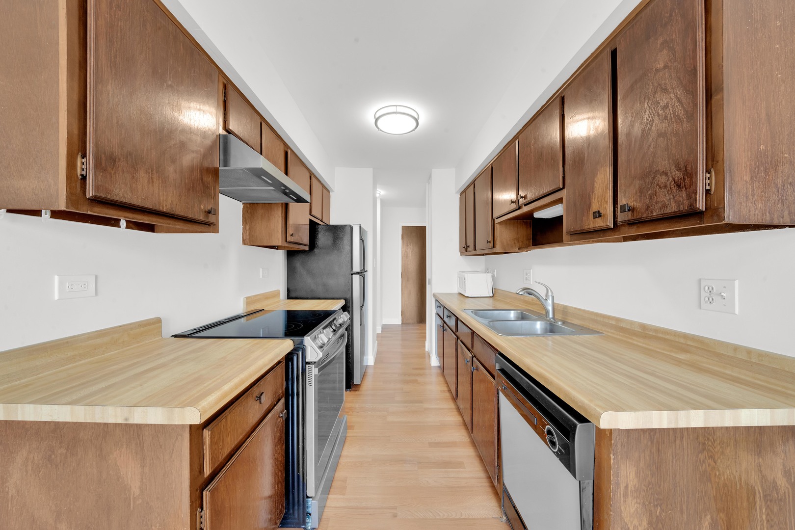 725 West Huntington Commons Road, Unit 314 Mount Prospect, IL 60056 - Photo 9 of 24 a kitchen with stainless steel appliances sink stove microwave and cabinets