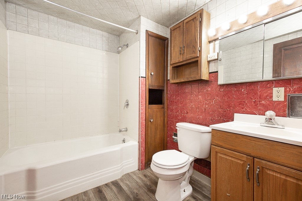 4574 Broadview Road Cleveland, OH 44109 - Photo 9 of 30 Full bathroom with vanity, hardwood / wood-style floors, tile walls, tiled shower / bath combo, and toilet
