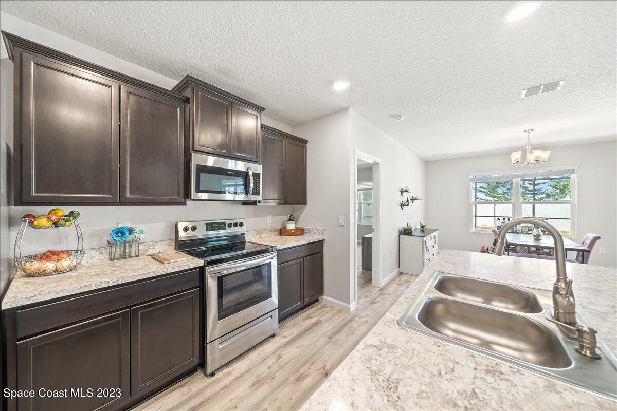 4480 Pagosa Springs Circle Melbourne, FL 32901 - Photo 5 of 41 a kitchen with a sink stove and refrigerator