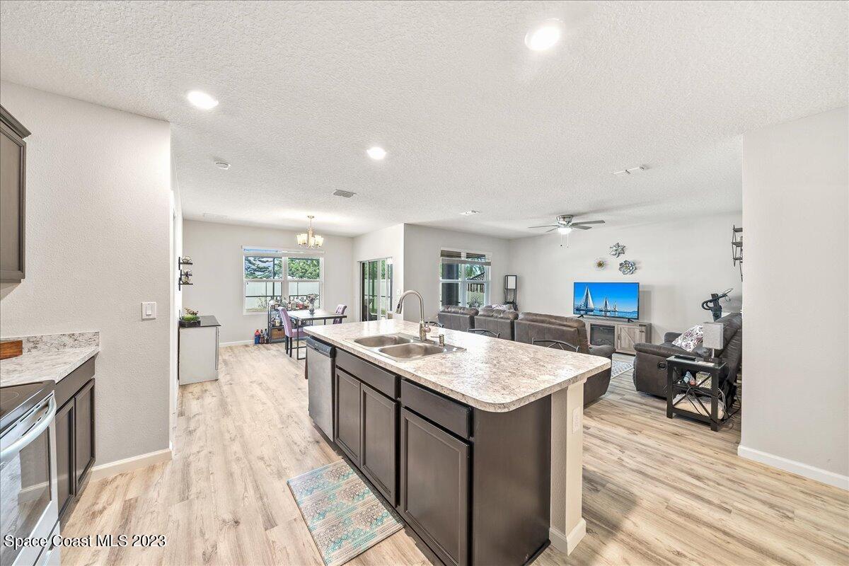 4480 Pagosa Springs Circle Melbourne, FL 32901 - Photo 8 of 41 a large kitchen with kitchen island a sink stove and wooden floor