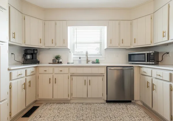 a kitchen with white cabinets and white appliances
