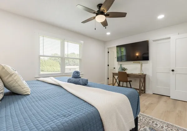 a bedroom with bed tv and window