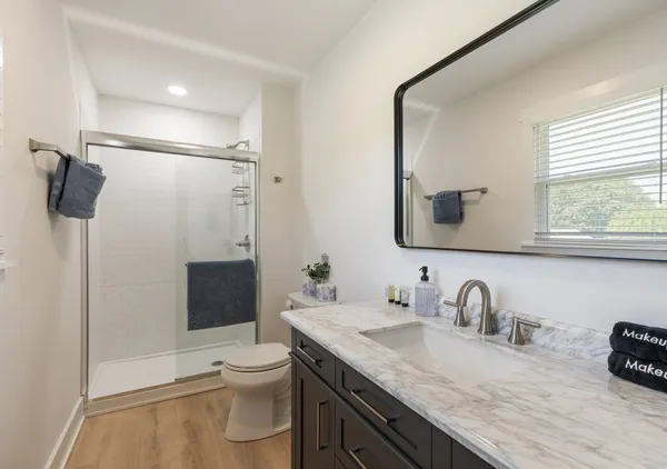 a bathroom with a granite countertop sink toilet and shower