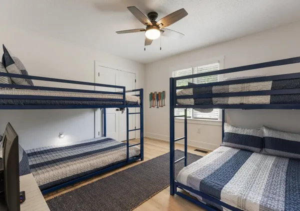 a bedroom with a bed and a ceiling fan