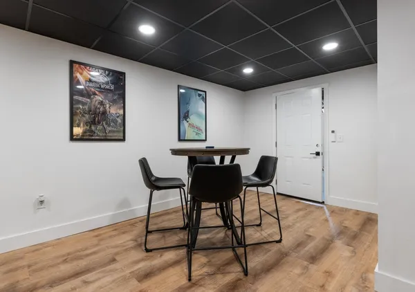 a view of a roof deck with table and chairs a barbeque with wooden floor and fence
