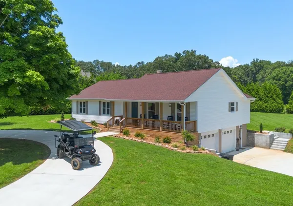 a aerial view of a house with table and chairs and wooden fence