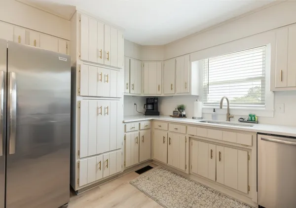 a kitchen with white cabinets and white appliances