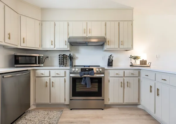 a kitchen with stainless steel appliances granite countertop a stove a sink and a refrigerator