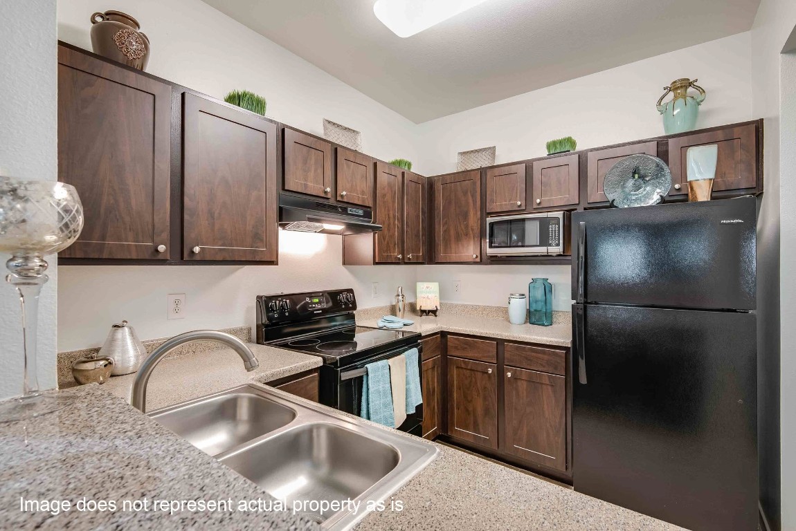 2400-1133 Spring Rain Drive Spring, TX 77379 - Photo 6 of 29 a kitchen with stainless steel appliances granite countertop a sink stove and refrigerator