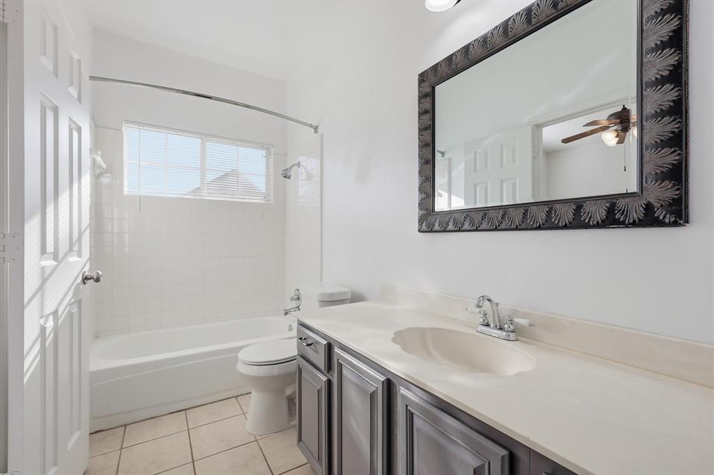 5023 Falcon Hollow Road McKinney, TX 75072 - Photo 20 of 25 Bathroom featuring vanity, bathtub / shower combination, light tile patterned floors, and a ceiling fan