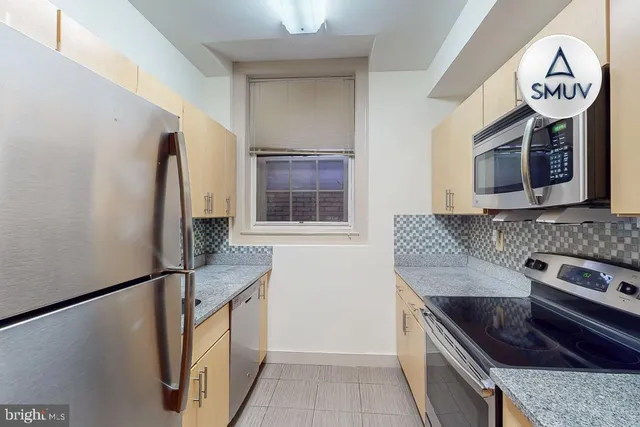 a kitchen with stainless steel appliances granite countertop a refrigerator and a stove