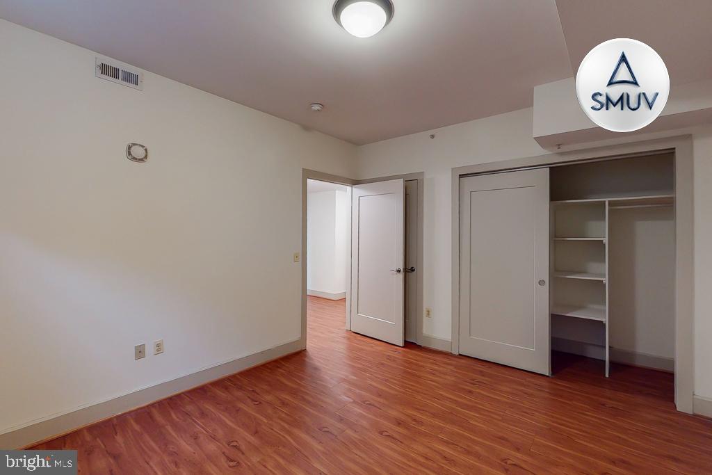 11 East Chase Street, Unit T03 Baltimore, MD 21202 - Photo 11 of 22 a view of a hallway to room with wooden floor