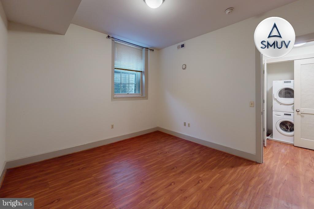 11 East Chase Street, Unit T03 Baltimore, MD 21202 - Photo 18 of 22 an empty room with wooden floor and mirror
