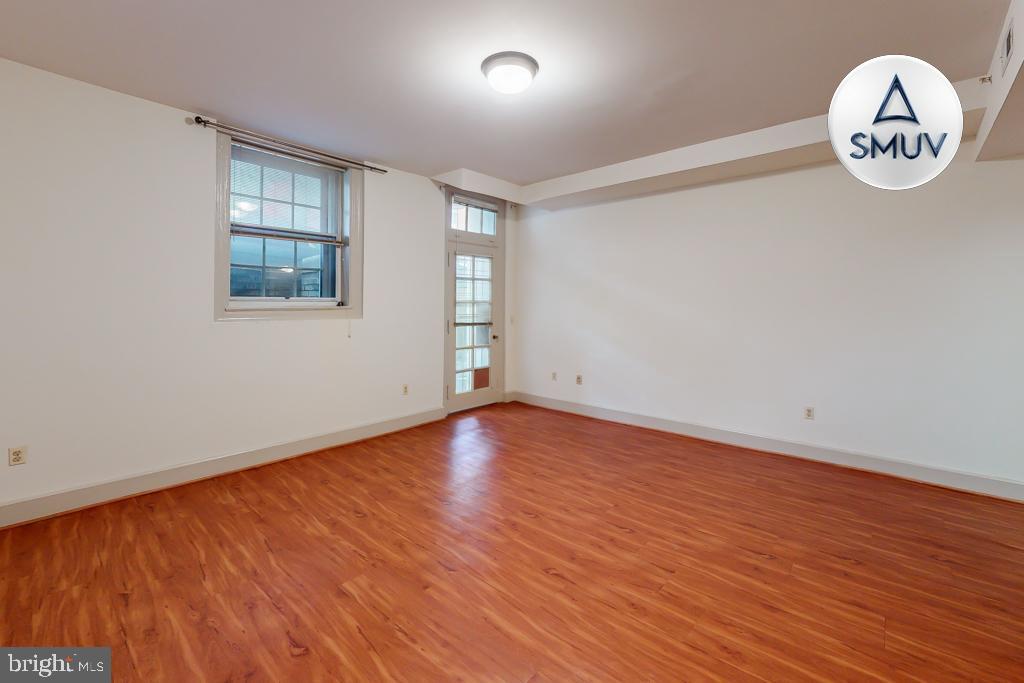11 East Chase Street, Unit T03 Baltimore, MD 21202 - Photo 21 of 22 an empty room with wooden floor and windows