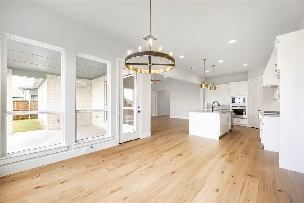 799 Mandrake Road Haslet, TX 76052 - Photo 10 of 27 a view of a kitchen with kitchen island wooden floors appliances and windows