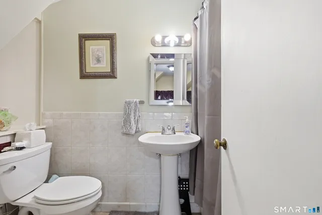 a bathroom with a toilet sink and mirror