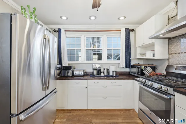 a kitchen with stainless steel appliances a sink stove and refrigerator