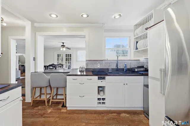 a kitchen with granite countertop a sink cabinets and refrigerator