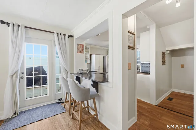 a view of a hallway with wooden floor and furniture and windows