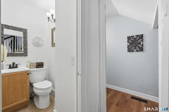 a bathroom with a toilet a sink and mirror