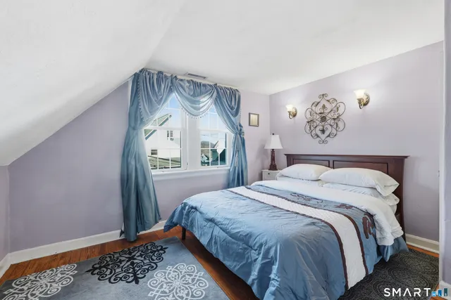 a bedroom with a bed and a painting on the wall