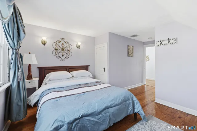 a bedroom with a bed and painting on the wall