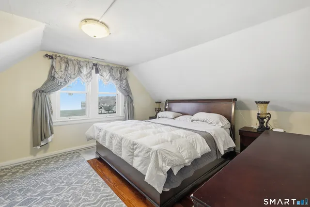 a bedroom with a bed next to a window