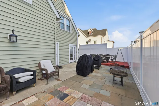 a view of a patio with a table and chairs and a barbeque