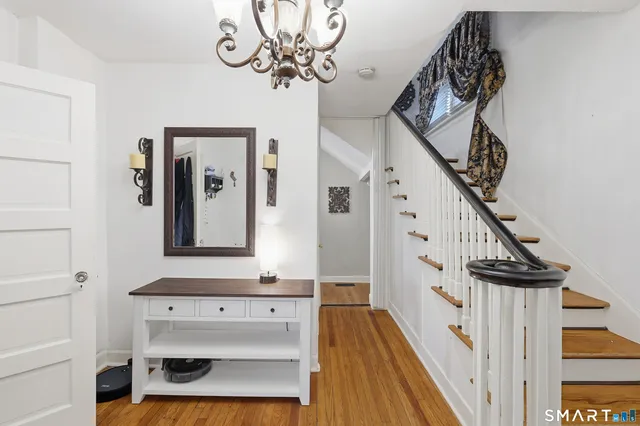a view of a hallway with wooden floor and staircase