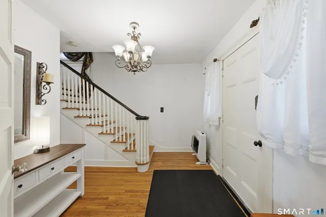 a view of entryway and hall with wooden floor