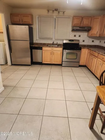 a kitchen with stainless steel appliances granite countertop a refrigerator a sink a stove a microwave and cabinets