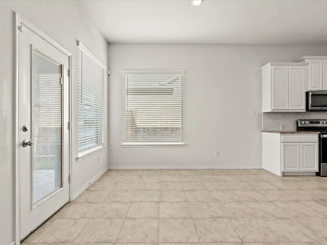 a view of an empty room with a kitchen