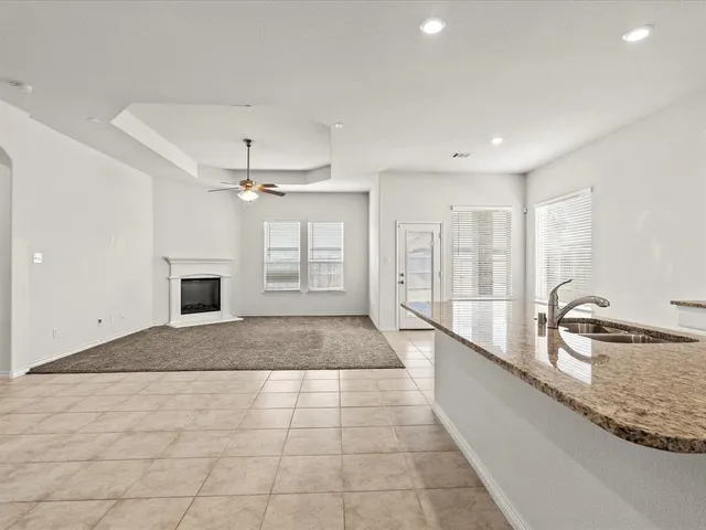 a large white kitchen with a large window and stainless steel appliances