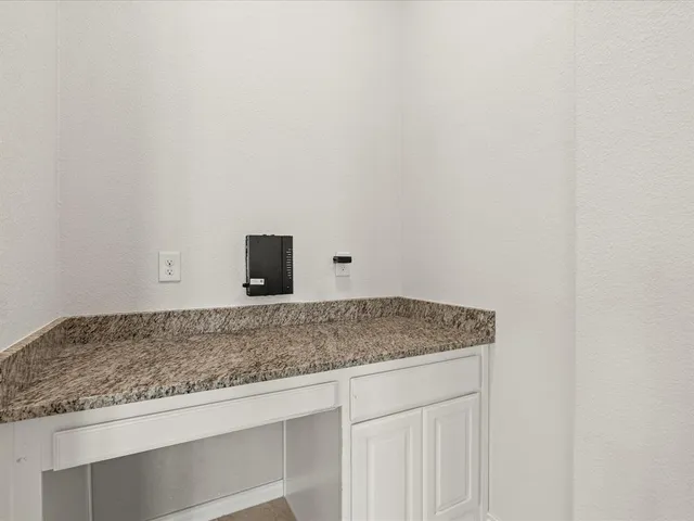a bathroom with a granite countertop and white cabinets