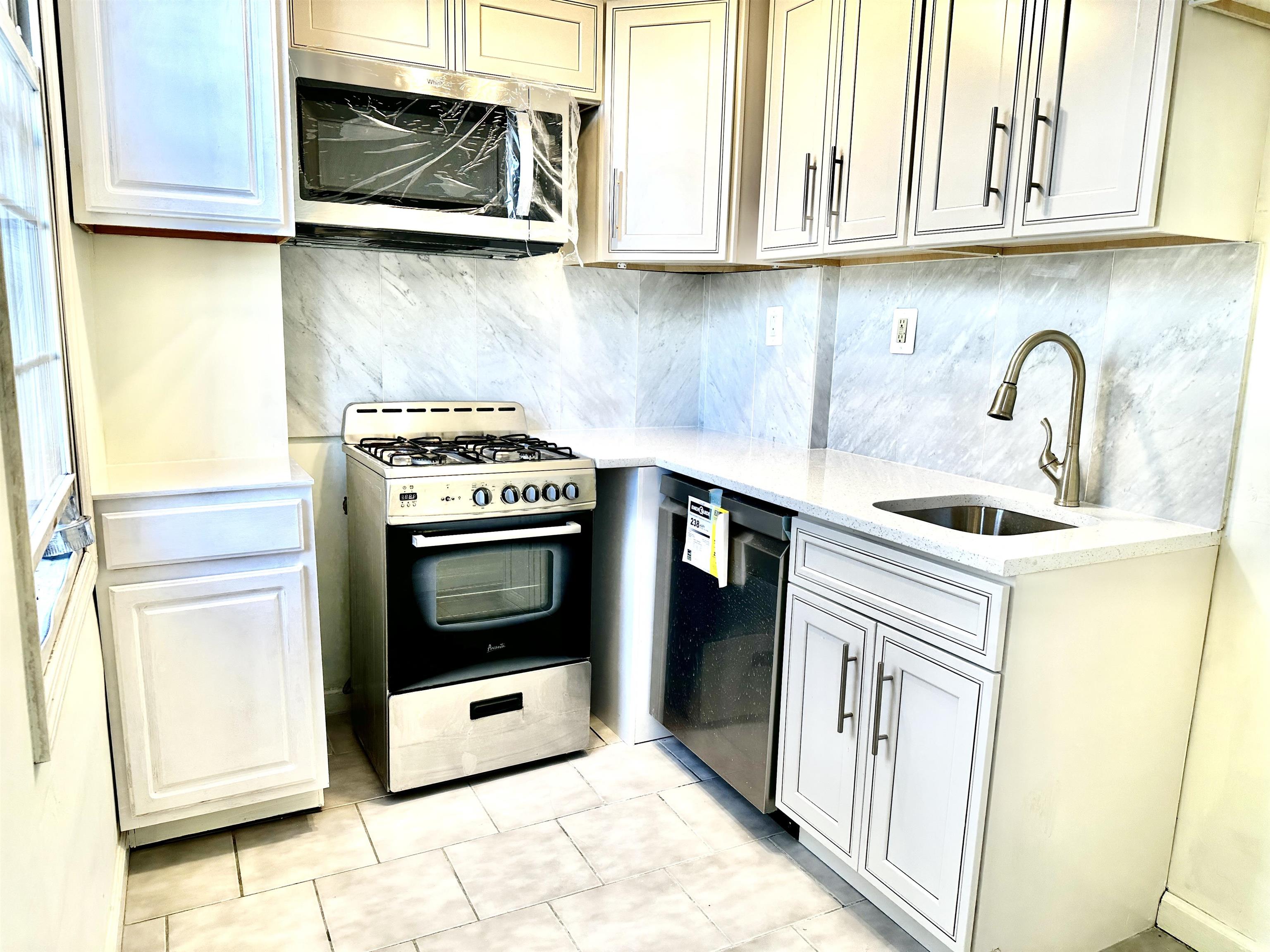 a kitchen with stainless steel appliances a stove a microwave and cabinets