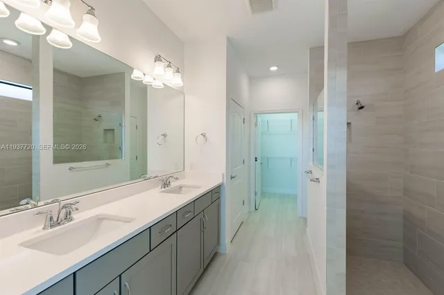 a bathroom with a double vanity sink mirror and shower