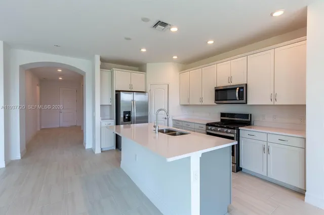 a kitchen with white cabinets and stainless steel appliances