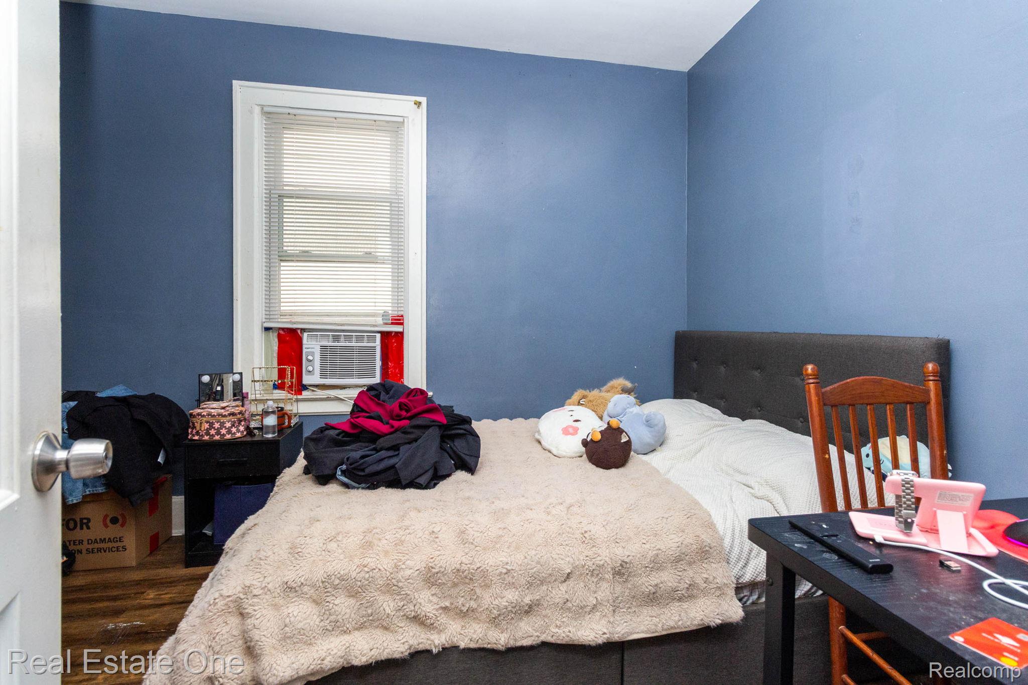 5485 Springwells Street Detroit, MI 48210 - Photo 16 of 47 Room with wood-finish flooring, a white window frame, and blue walls