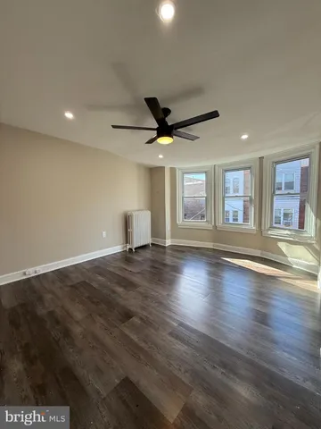 a view of a livingroom with a ceiling fan and wooden floor
