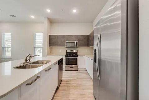 a kitchen with kitchen island a sink appliances and cabinets