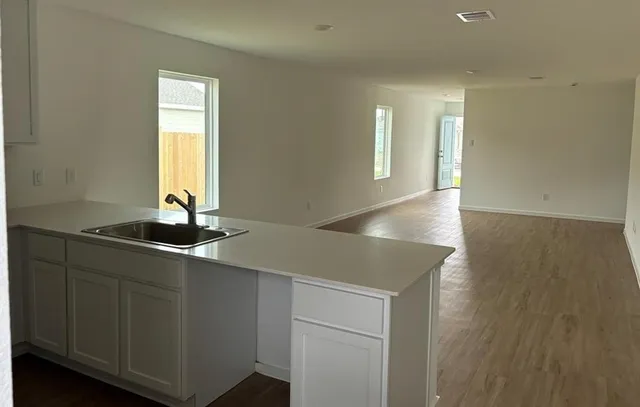 a kitchen with stainless steel appliances a sink cabinets and a window