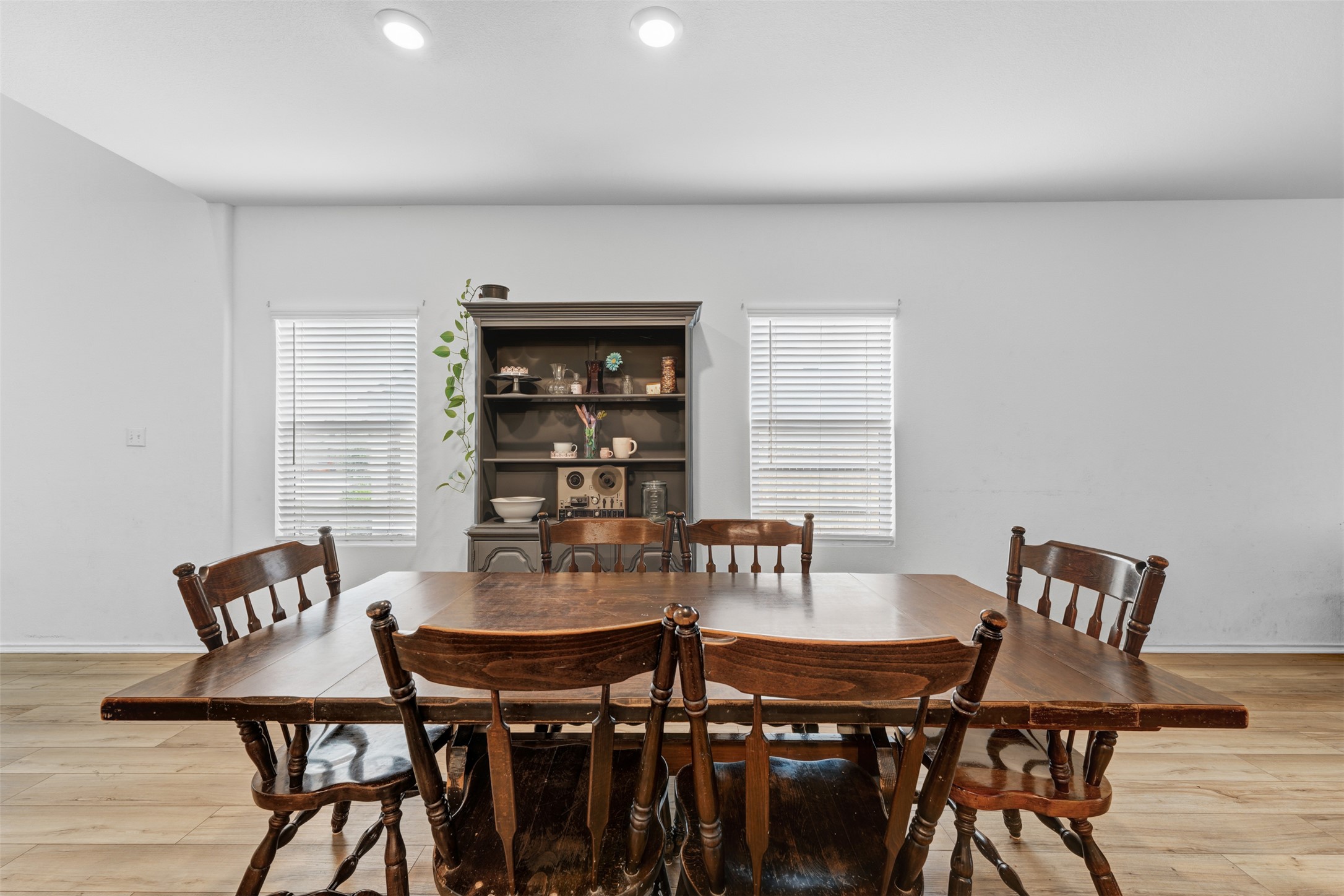 413 Perfect World Loop Jarrell, TX 76537 - Photo 9 of 39 Recessed lighting illuminates this inviting dining area with natural wood flooring and a classic display hutch.