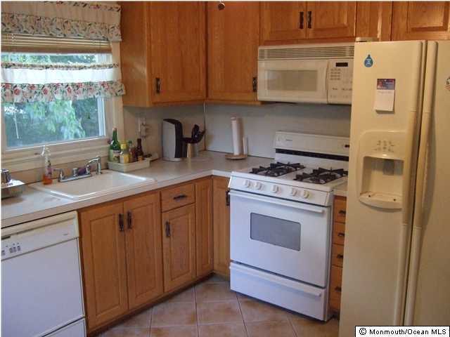 239 Oakhurst Road Oakhurst, NJ 07755 - Photo 3 of 3 a kitchen with stainless steel appliances granite countertop a sink stove and refrigerator