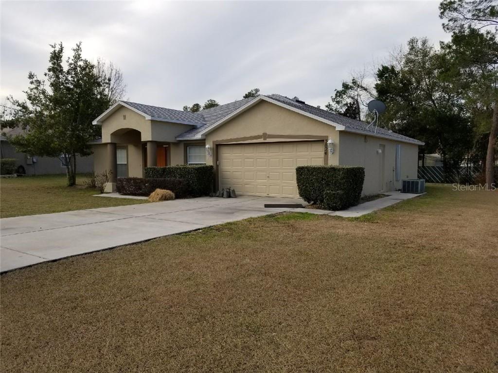 a view of a house with backyard and trees