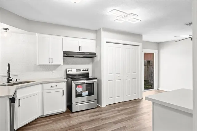 a kitchen with stainless steel appliances granite countertop a refrigerator and a stove top oven