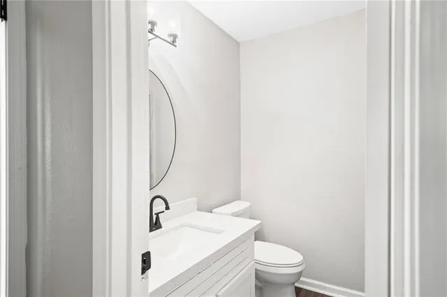 a bathroom with a sink a toilet and a mirror