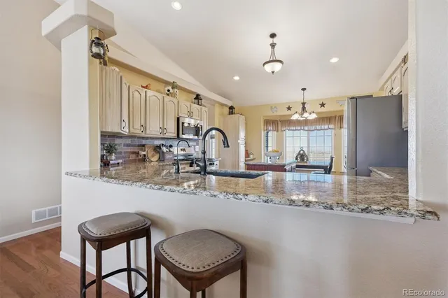 a kitchen with kitchen island granite countertop a sink cabinets and appliances